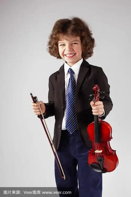 聪明的小男孩拿着小提琴,笑着看着镜头.