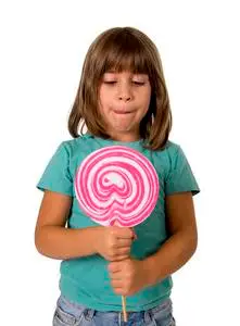 4岁或5岁的小女孩吃大粉色棒棒糖照片