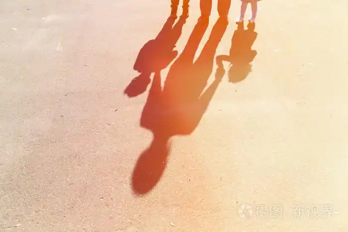 母亲带着儿子和女儿手牵手的阴影