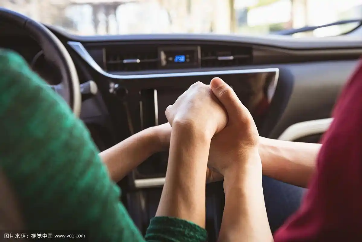 在车里牵着手的夫妇