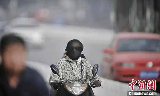 10月10日,一位天津市民用纱巾包裹头部并带着口罩出行.