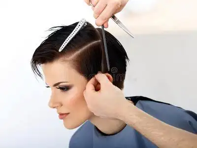 理发师在美容院为女性理发.照片
