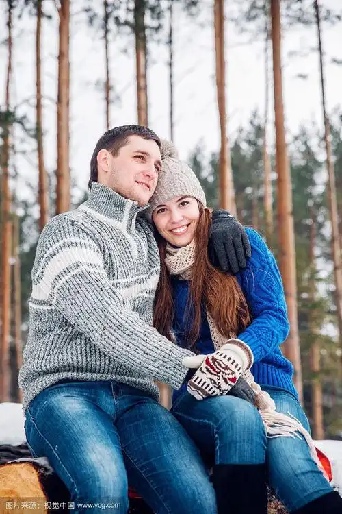 圣诞快乐相爱的情侣拥抱在冰雪皑皑的冬天寒冷的森林里