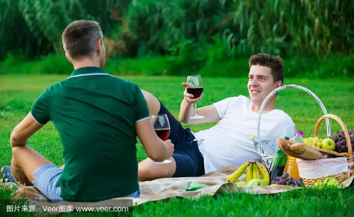 男性与朋友在野餐时喝酒