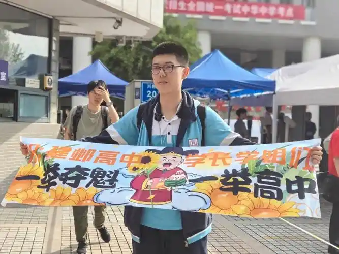 南师大附中考点门口,一位考生的父母双双着红衣送考.