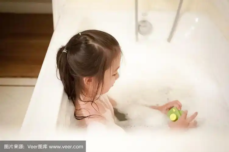 顽皮的小女孩用一个浴缸玩具洗泡泡浴