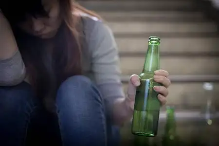 沮丧的妇女在地下酗酒感到心烦照片