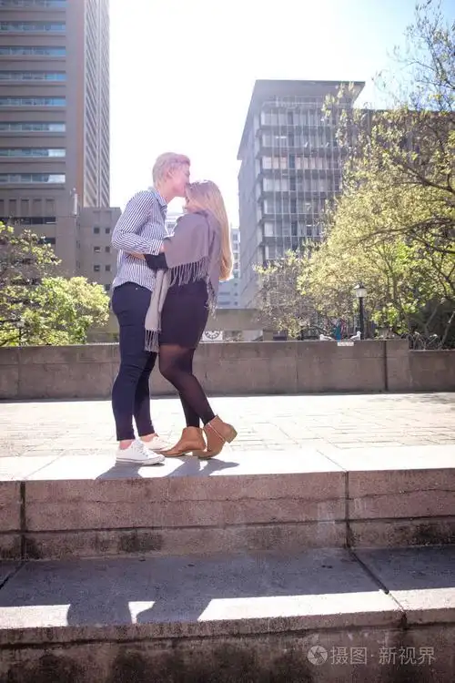 二十岁在南非开普敦两个女同性恋女同性恋者拥抱在城市景观中的一条黑