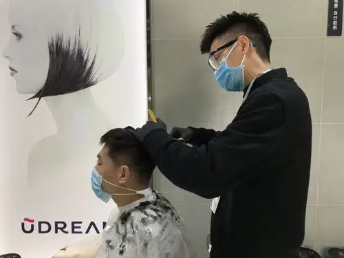 全副武装的理发师正为顾客理发.