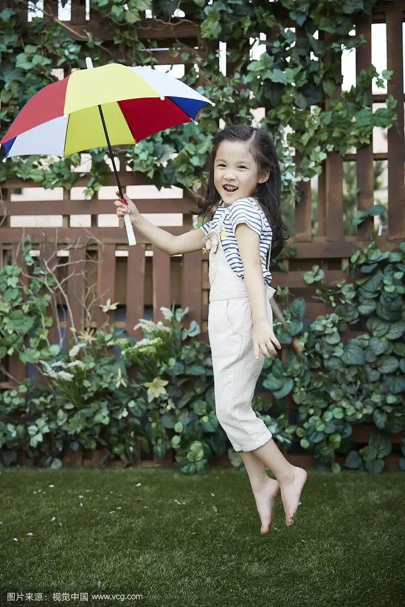 幼儿园小女孩撑伞赤脚跳的照片