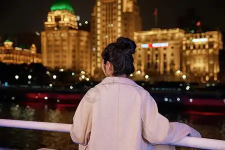 夜晚站在栏杆前看夜景的女生背影图片素材