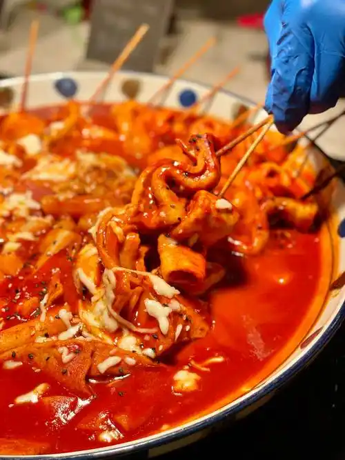 咕嘟嘟冒泡的酱汁融化了马苏里拉奶酪,鱼饼串的咸香和年糕的软糯甜甜