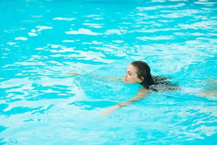 年轻女子在游泳池中游泳