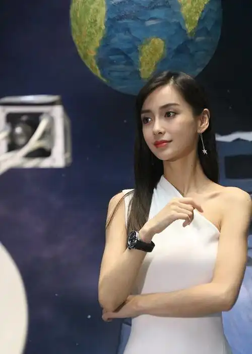 她身穿白色斜肩裙,搭配黑长直发,女神范十足.