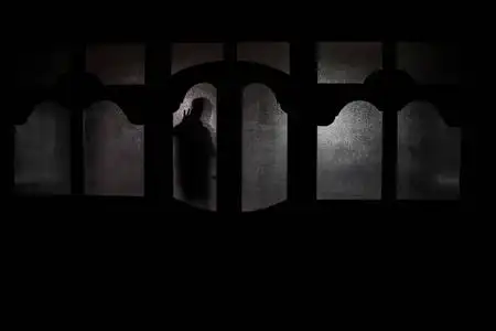 一个人在夜晚的窗口前的剪影.恐怖场面万圣节模糊剪影概念照片