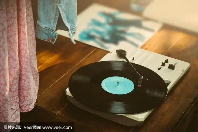 木桌上放着媒体播放器和黑胶唱片.复古电影滤镜色调