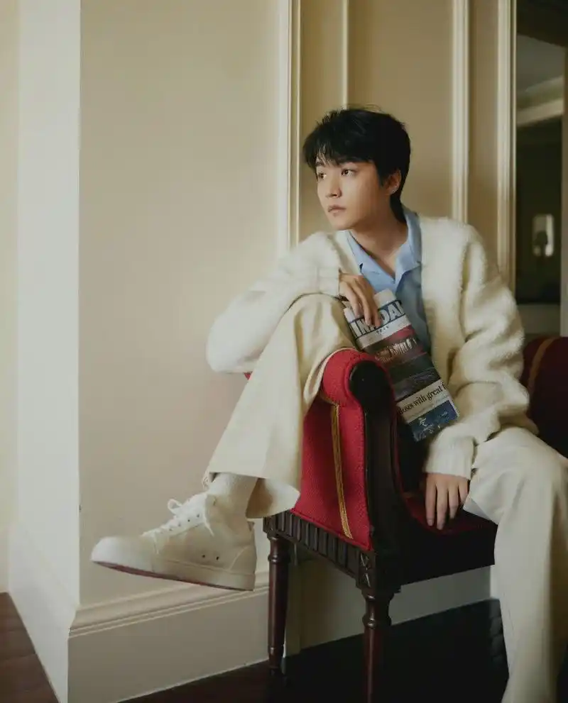 王俊凯身穿开衫毛衣,蓝色衬衫,白色袜子和白色鞋子.