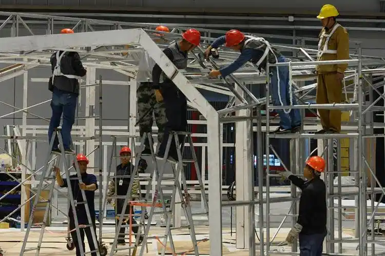 在搭建展区的过程中,工人们爬上爬下是不可避免的.