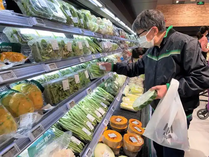 消费者在生鲜超市挑选蔬菜