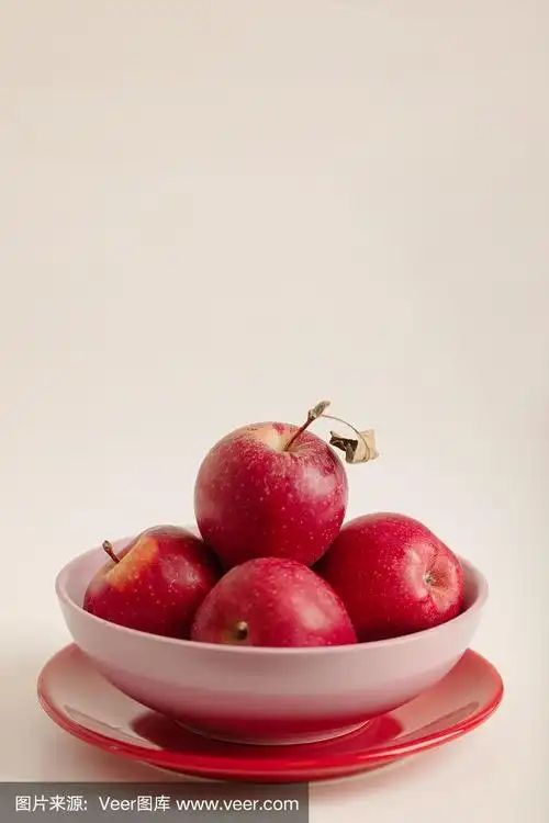 红绿苹果放在白色背景的盘子上.