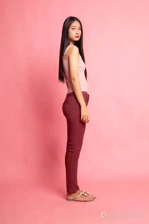 侧面丰满的美丽的年轻亚洲女人粉红色的背景