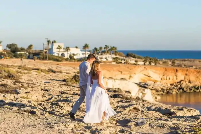 美丽的年轻夫妇手牵手在沙滩上