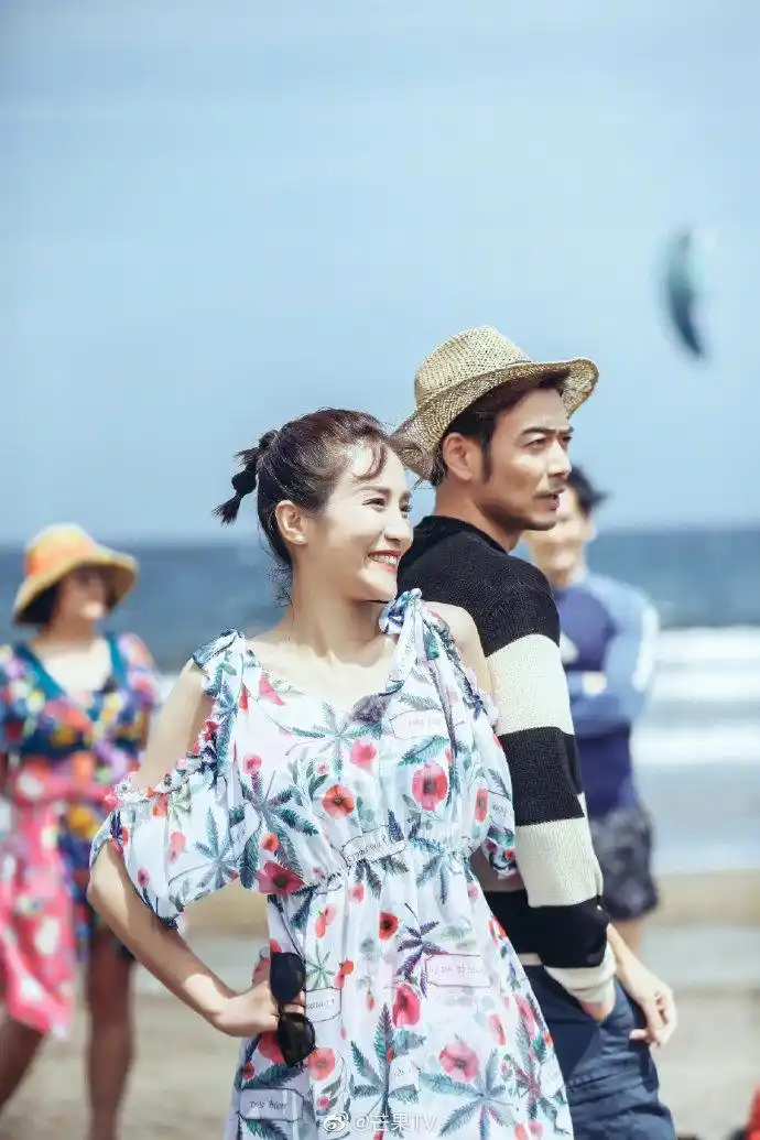 小两口手牵手在沙滩漫步,粉红色泡泡都要溢出屏幕啦!