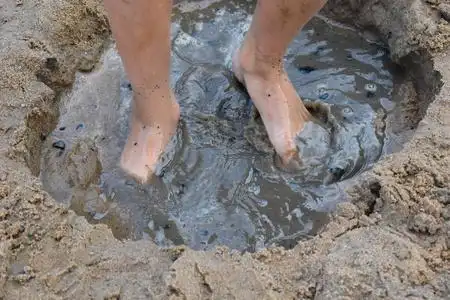 情绪活跃夏天男孩在河岸上玩泥巴.活跃儿童h照片