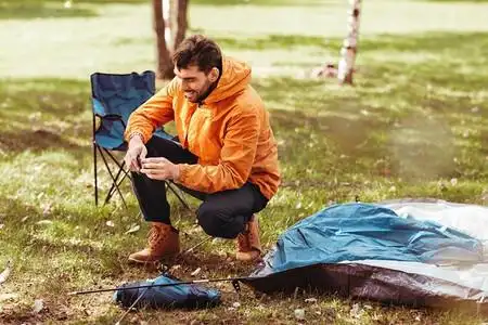 露营,旅游和概念-男人在户外搭帐篷.油画佛像