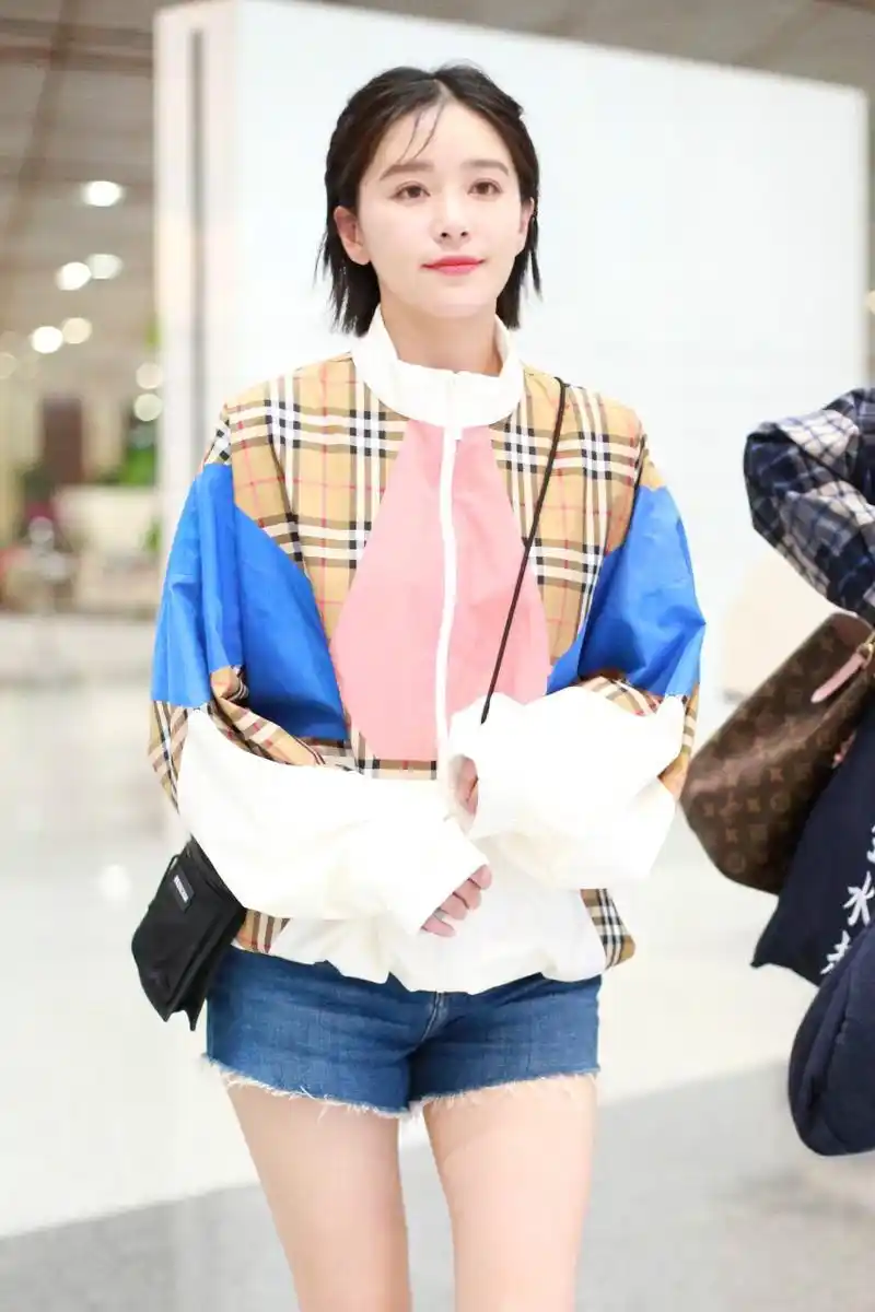 阚清子穿拼色卫衣搭配蓝色牛仔短裤现身机场,皮肤白皙面带微笑