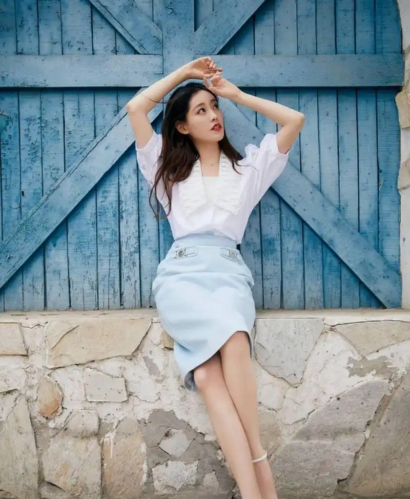 巧笑嫣然的#祝绪丹# 身穿白色衬衣配蓝色半身裙,雪肤玉貌,身材曼妙