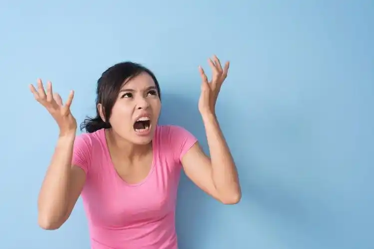 灰色背景下生气的年轻女人