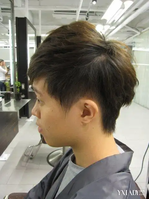 这是一位头顶上的头发有点小长的男生的内掏空式的发型,头发看起来还