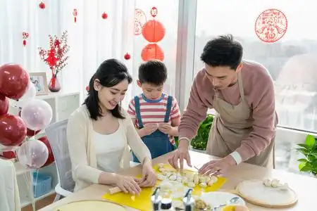 快乐的年轻家庭包饺子照片