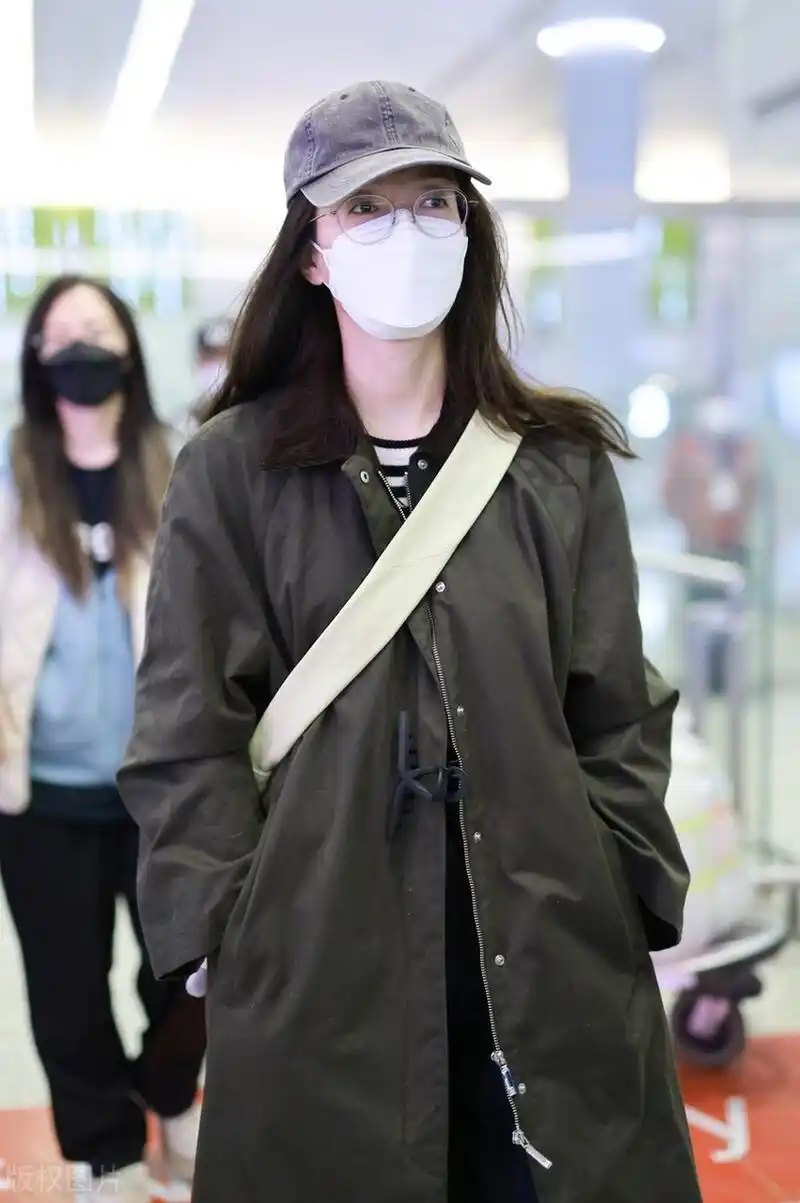 江疏影机场街拍,军绿色的大衣搭配条纹t恤,头戴棒球帽清新又减龄.