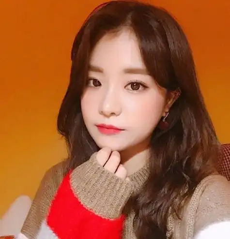 看这位梳偏分栗色波浪卷中长发的小瓜子脸女生,既有少女的阳光灵动