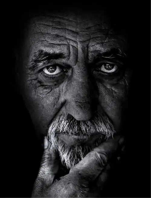 黑色背景下伤感严肃的老人的黑白图像