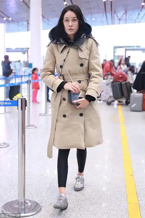 "龙女郎"张蓝心素颜亮相机场 卡其色大衣束腰露小气腿身材高挑