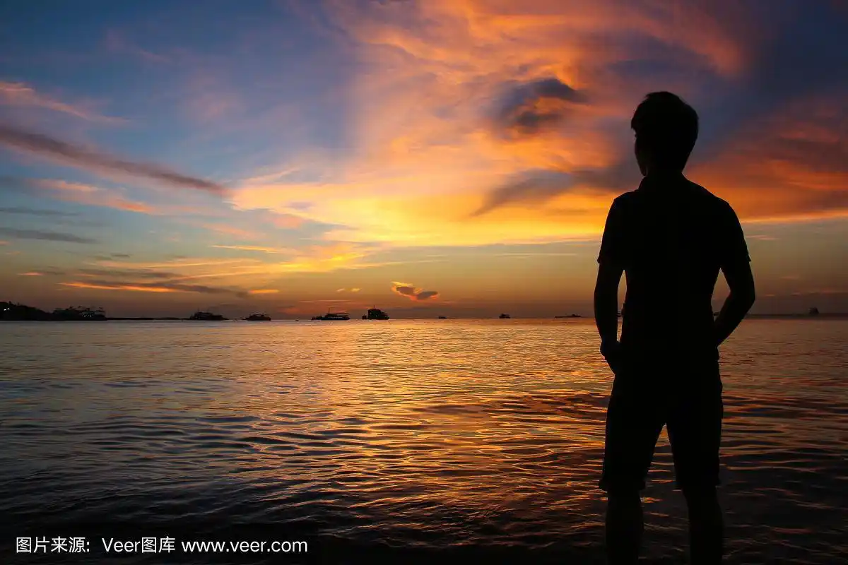 海滩上日落时男人的剪影