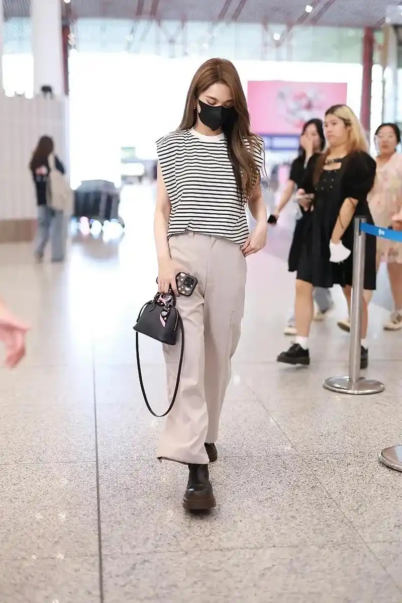 杨丞琳最新机场照来了,她穿了一件黑白条纹的圆领t恤,这t恤是连肩袖的