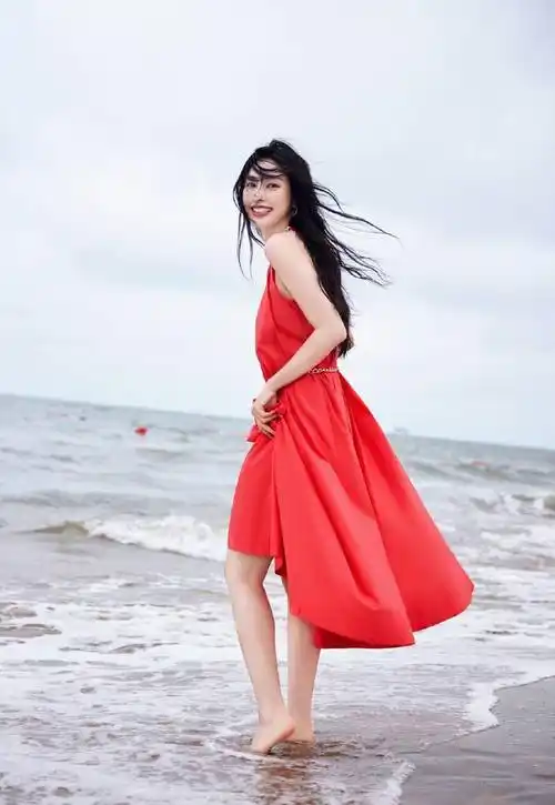 张俪穿红色长裙赤脚漫步海边,海风吹动长发回眸氛围感拉满_成为了