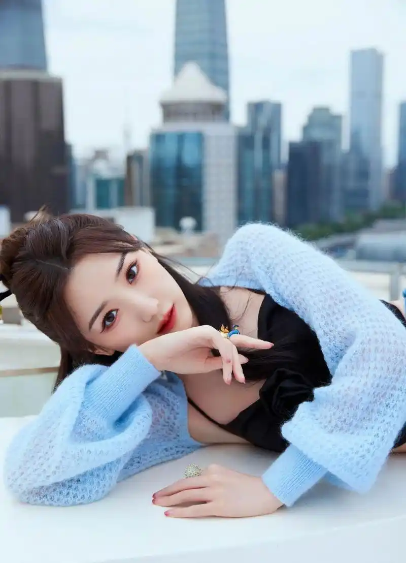 毛晓彤晒街拍穿搭,蓝色针织衫内搭黑色吊带衫温柔又性感,配上牛仔裤