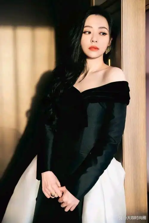 张靓颖身着一套典雅的黑色与纯粹的白色相间的礼服,展现出她独特的的