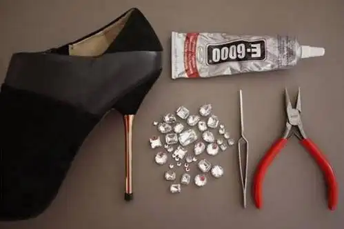 首先在容器里倒入胶水, 用镊子夹起水钻粘上胶水, 将水钻粘在高跟鞋上