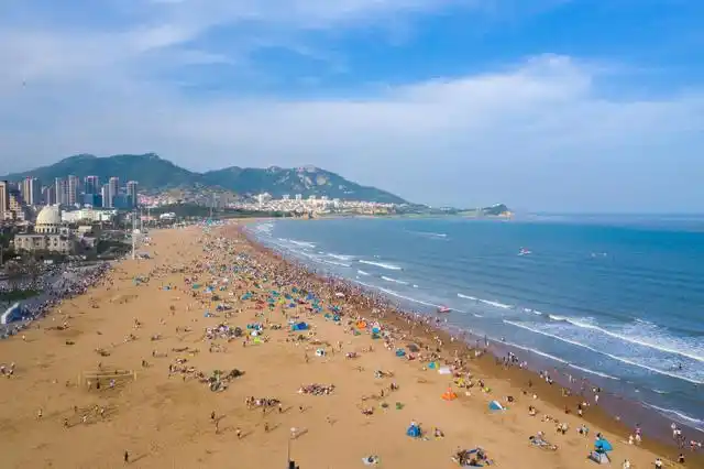 航拍青岛石老人海水浴场,天蓝蓝海蓝蓝,游客人头攒动流连忘返_网易
