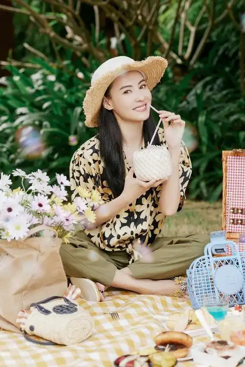 张柏芝身穿着碎花衬衫头戴草帽手捧黄白雏菊花束