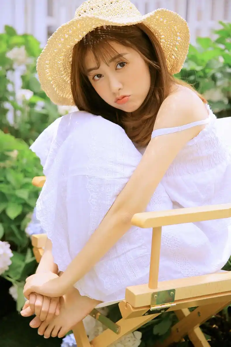 穿纯白连衣裙的少女,在阳光下笑容灿烂,美的像花儿一样