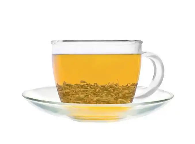 孤立茶叶绿茶散落茶叶散落绿茶茶叶夹子一杯绿茶放置在木制的桌子上餐