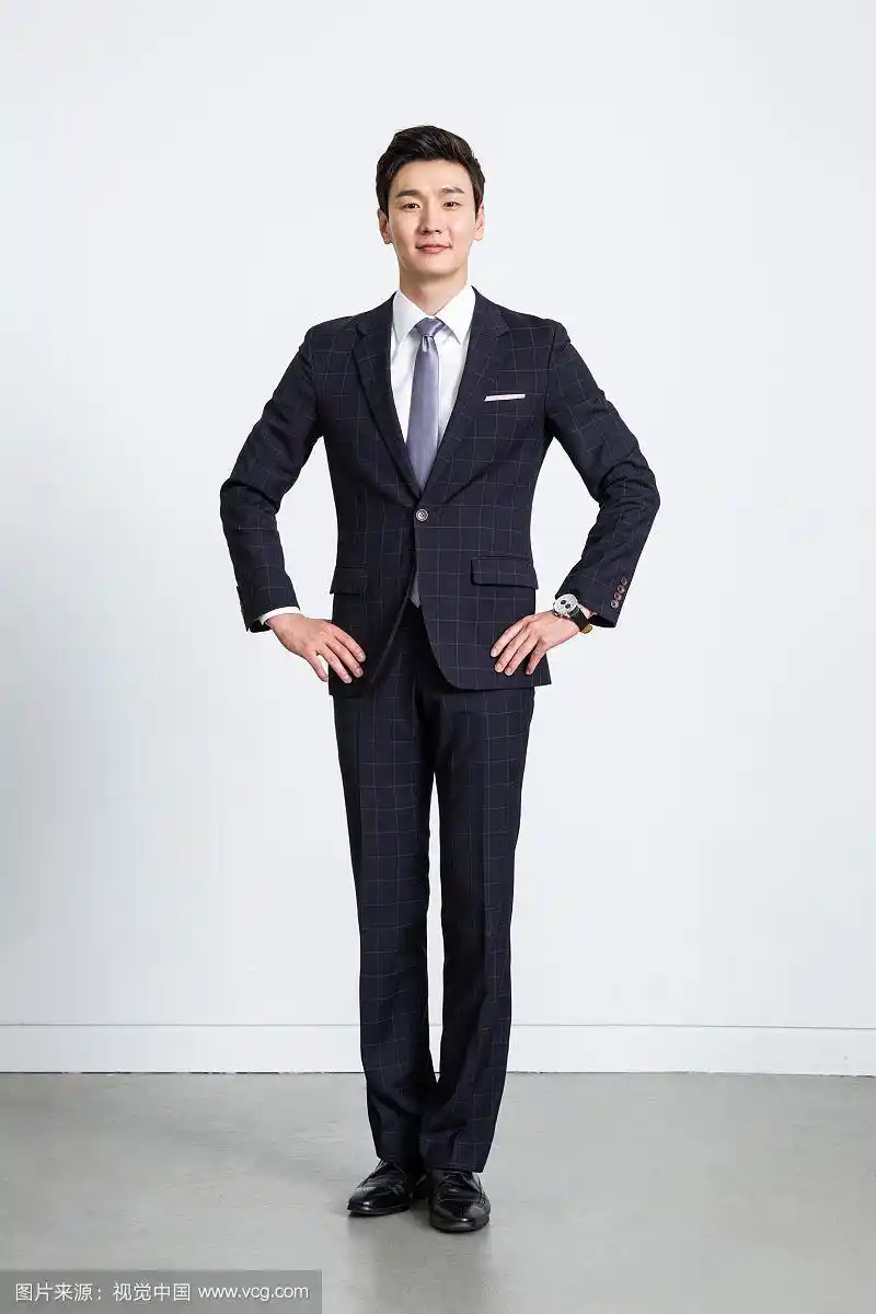 穿着西装的男人站着举着手势的照片