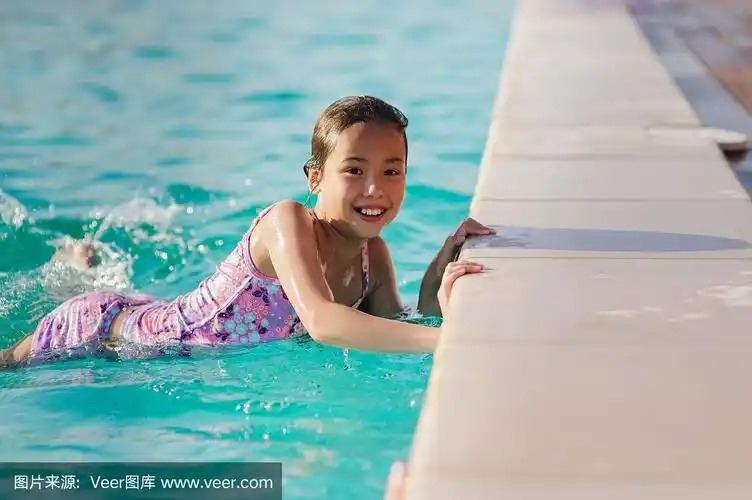 小女孩在蓝色的游泳池里